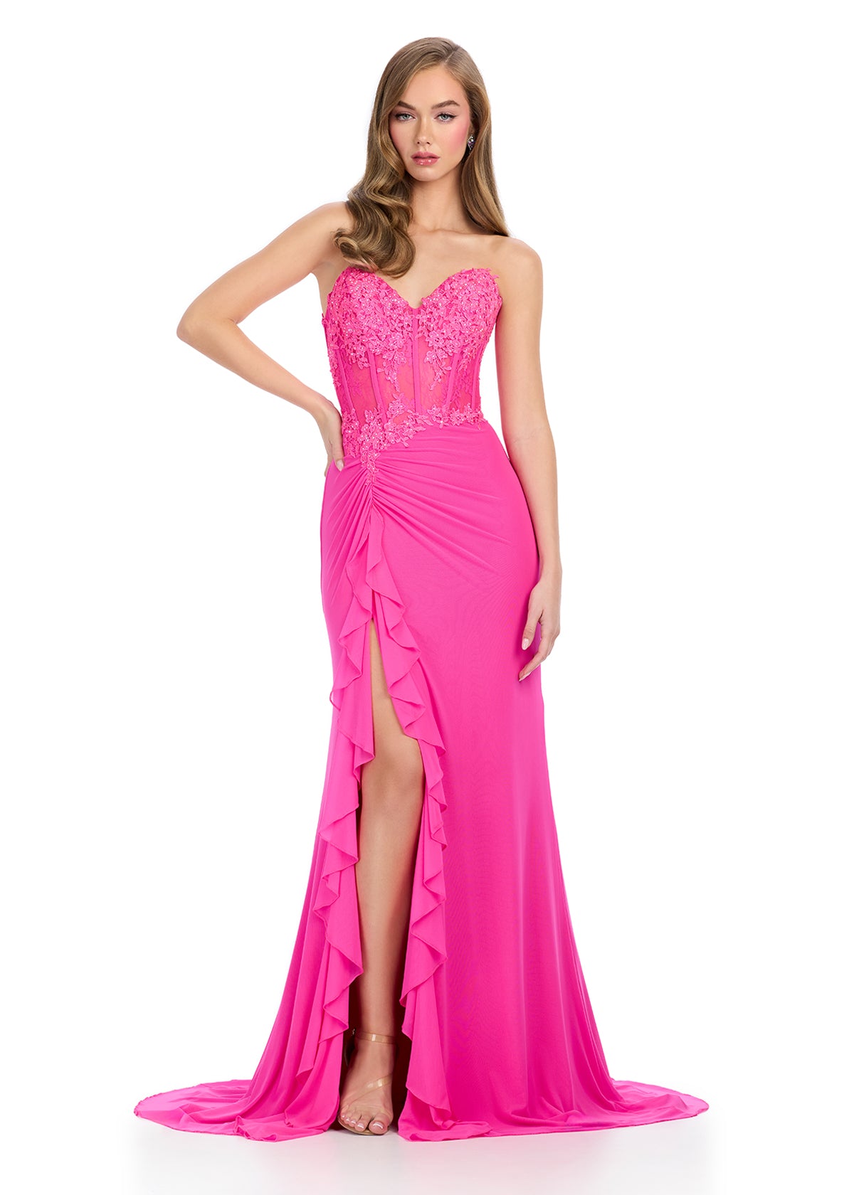 Statement-making gown featuring a structured corset bustier adorned with intricate embroidered appliqué, a ruffle-accented right leg slit, and a sweep train for a glamorous and elegant finish. Perfect for special occasions.
