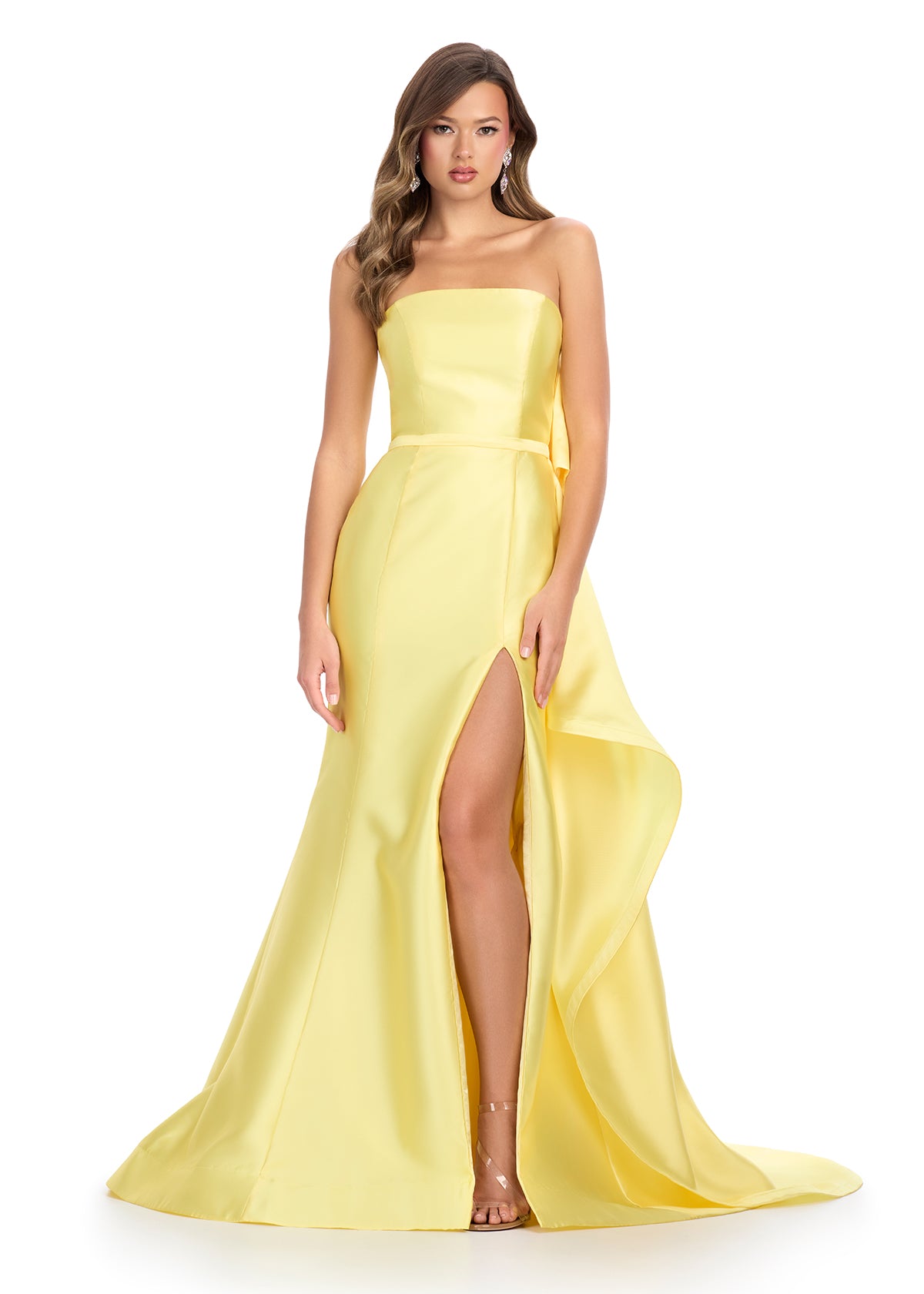 Elegant strapless mikado gown featuring a sleek belt, a left leg slit, and a statement back bow that cascades down onto the sweep train for a dramatic and sophisticated finish. Perfect for special occasions.