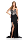 Sparkling strapless gown featuring a structured bustier adorned with press-on stones in an animal print-inspired pattern. Complete with a wrap skirt, right leg slit, and sweep train for a fierce and glamorous look. Perfect for special occasions.