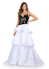Elegant ball gown featuring a velvet bodice with a sweetheart neckline, an asymmetrical drop waist, a fully beaded bow accent, and a multi-tiered satin skirt for a timeless black and white moment. Perfect for special occasions.