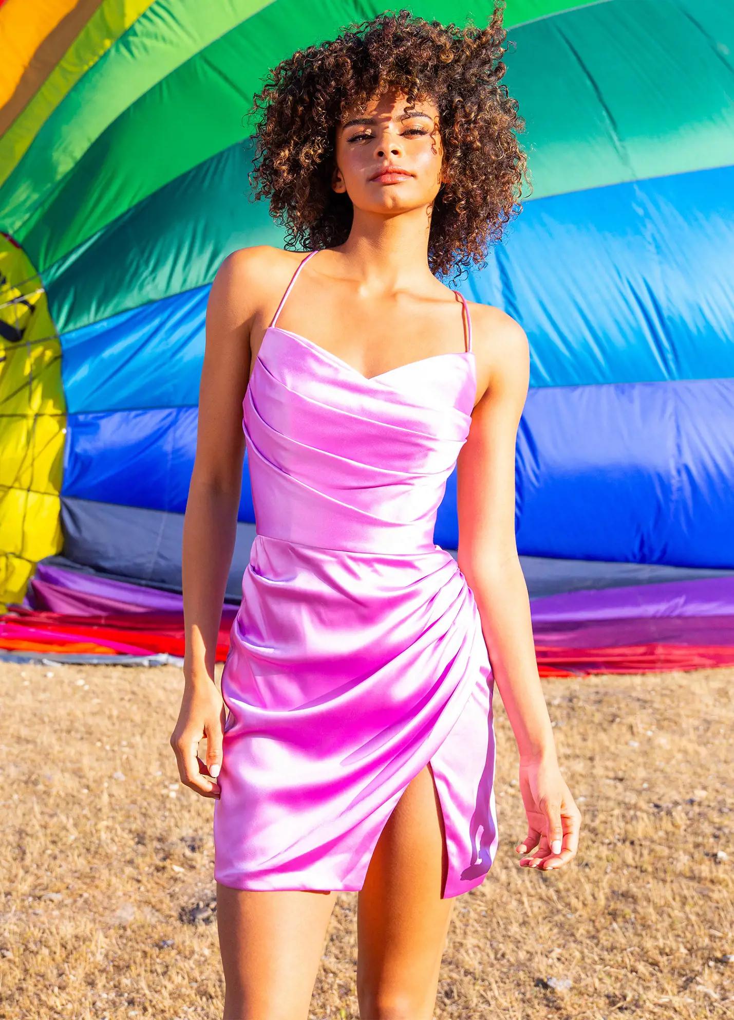 Pink ASHLEYlauren 4513 satin cocktail dress featuring spaghetti straps, an exquisitely draped bodice, wrap fitted skirt with a left leg slit, and an open lace-up back for an elegant and sophisticated look. Editorial