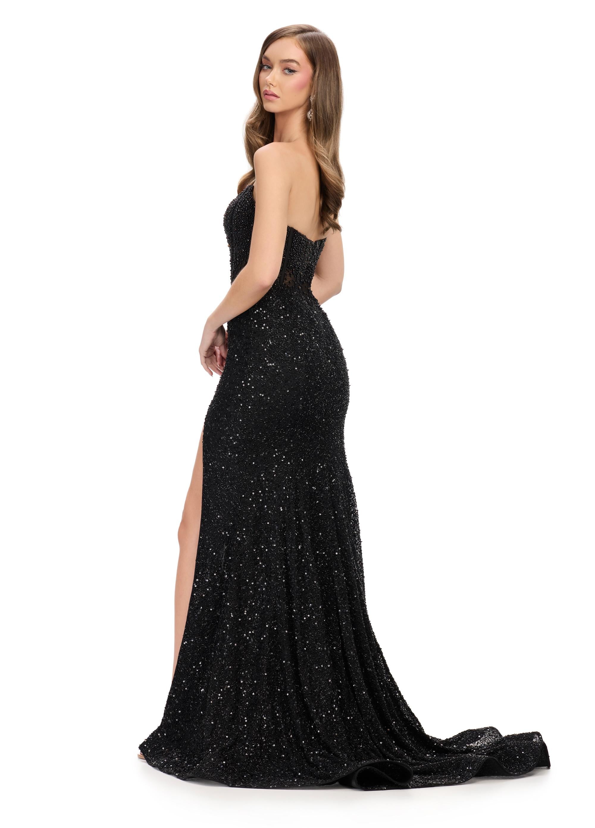 Back. Black ASHLEYlauren 11659 fully beaded gown featuring a strapless corset bustier, asymmetrical waistline to accentuate curves, fitted silhouette, left leg slit, and horsehair trim for an elegant and glamorous look.