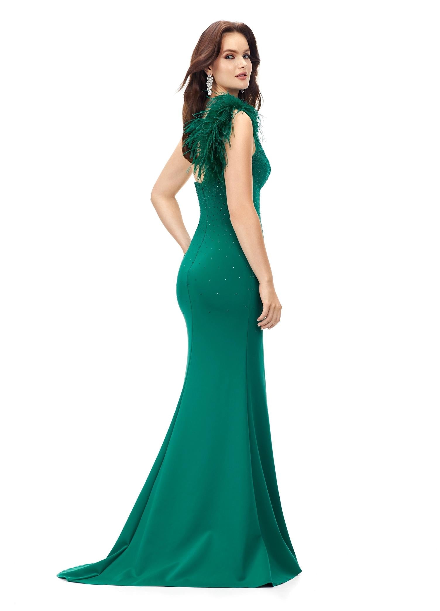 Back. Dark Emerald ASHLEYlauren 1129 one shoulder scuba gown featuring feather-embellished neckline, heat set stones cascading down the skirt, and a left leg slit for a bold and elegant look.