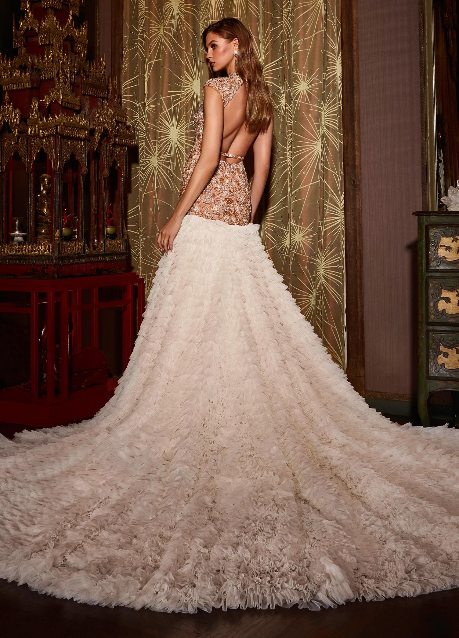 Back view. Ivory ASHLEYlauren 11428 breathtaking mermaid gown featuring a fully beaded drop waist bustier, open back, cap sleeves, and a dramatic tiered ruffle tulle skirt for an unforgettable look.