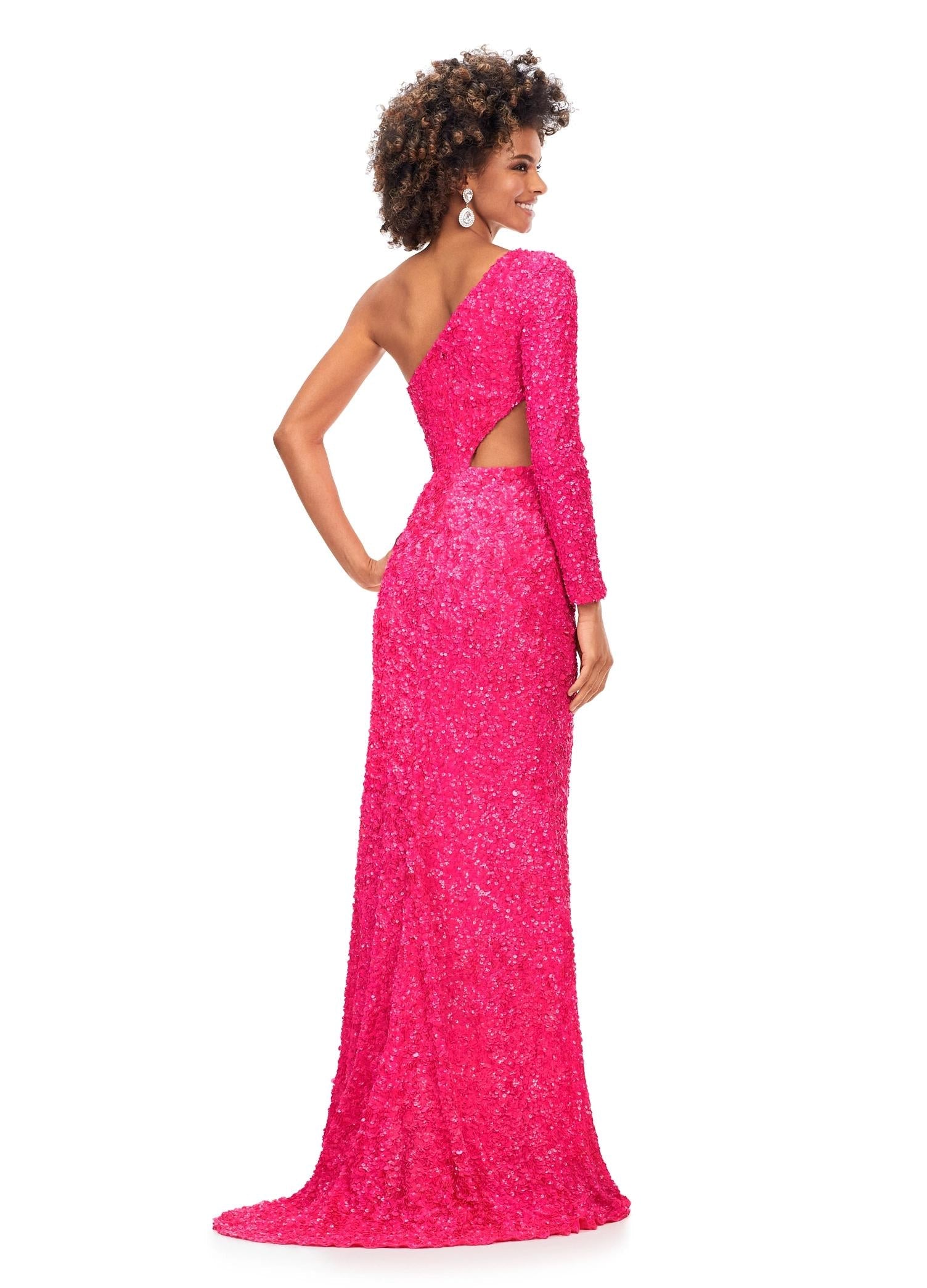 Back. Pink ASHLEYlauren 11340 sequin one shoulder gown featuring a single sleeve, shark bite cut-out, wrap skirt, and left leg slit for a striking and glamorous look.