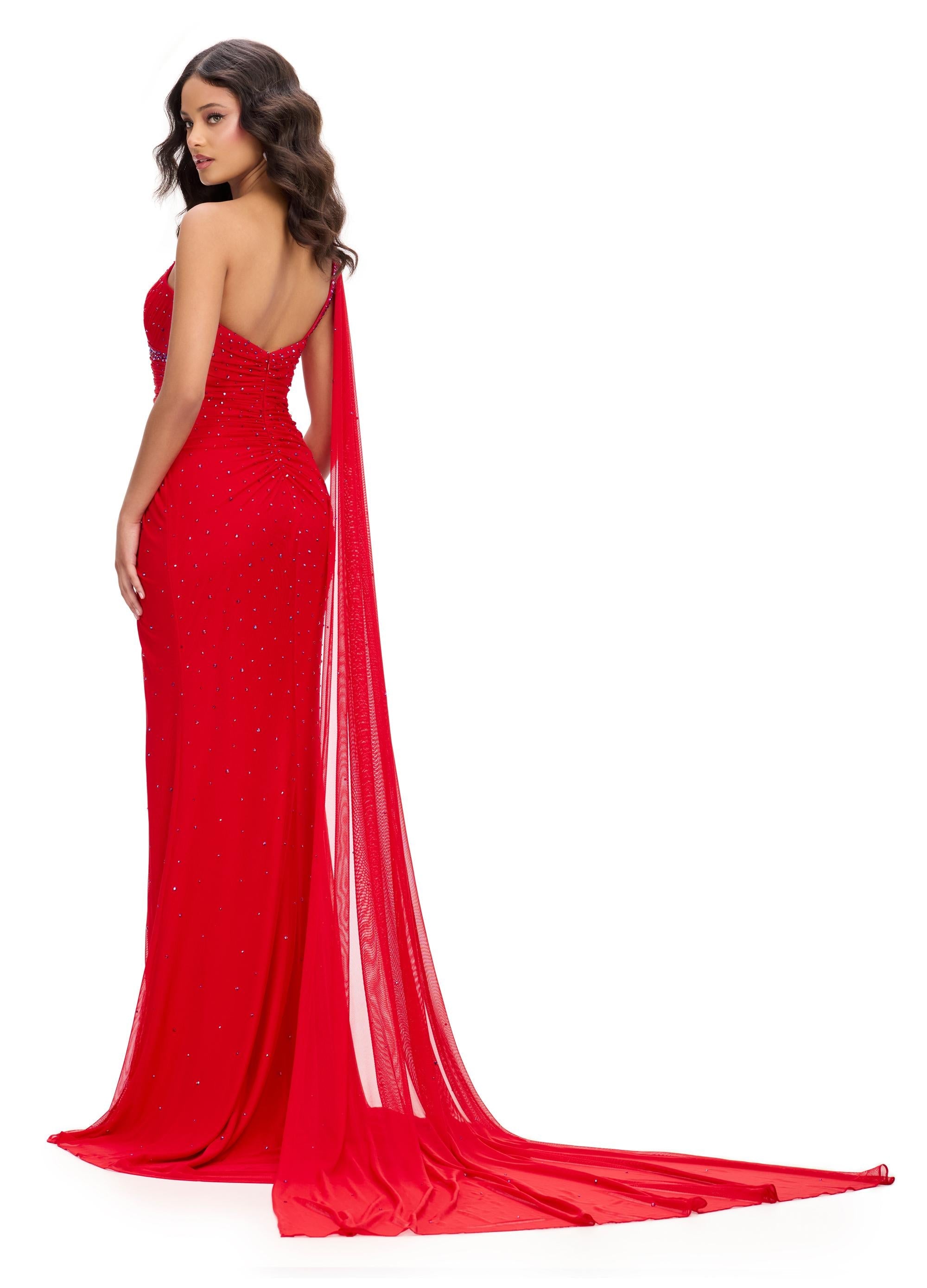 Back. Red ASHLEYlauren 11736 glamorous one shoulder gown featuring press-on stone embellishments, a dramatic one shoulder cape, and a left leg slit for an elegant and show-stopping look.