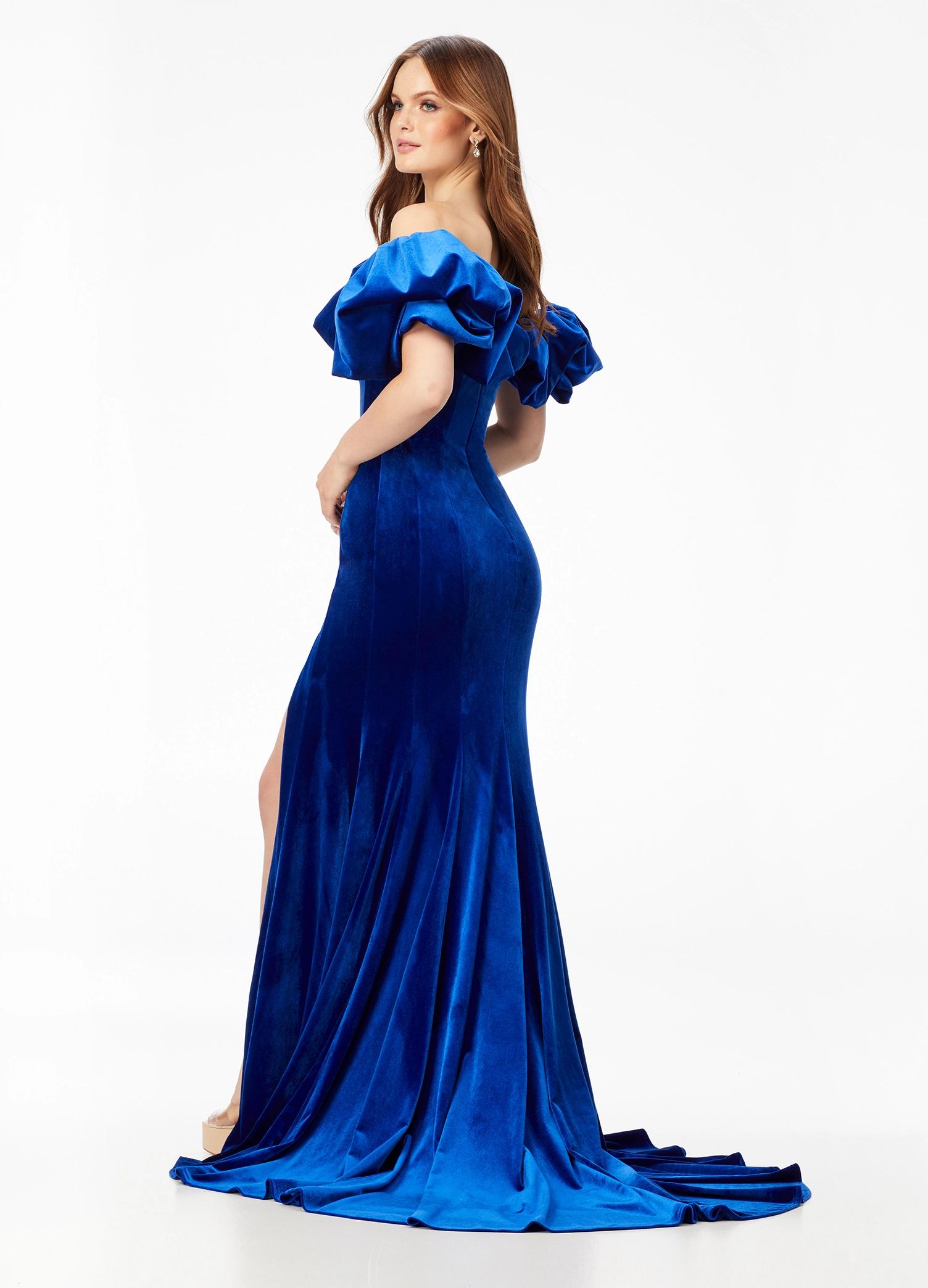 Back - Blue ASHLEYlauren 11217 – A magnificent off-shoulder velvet gown featuring oversized ruffle details, a contour seamed skirt with a left leg slit, and a dramatic train. Perfect for making a bold, elegant statement at any event.