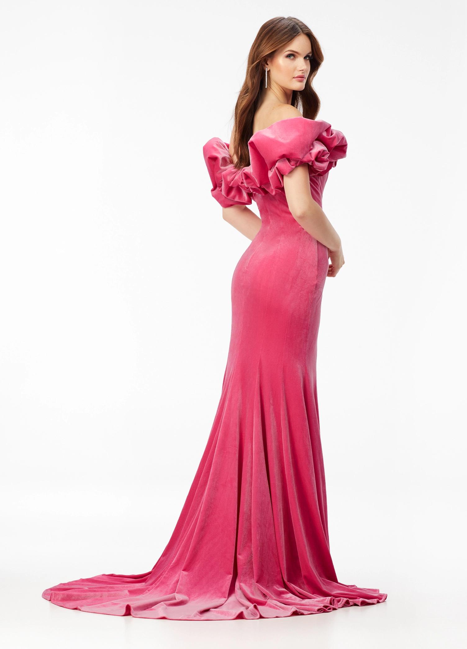 Back - Pink ASHLEYlauren 11217 – A magnificent off-shoulder velvet gown featuring oversized ruffle details, a contour seamed skirt with a left leg slit, and a dramatic train. Perfect for making a bold, elegant statement at any event.