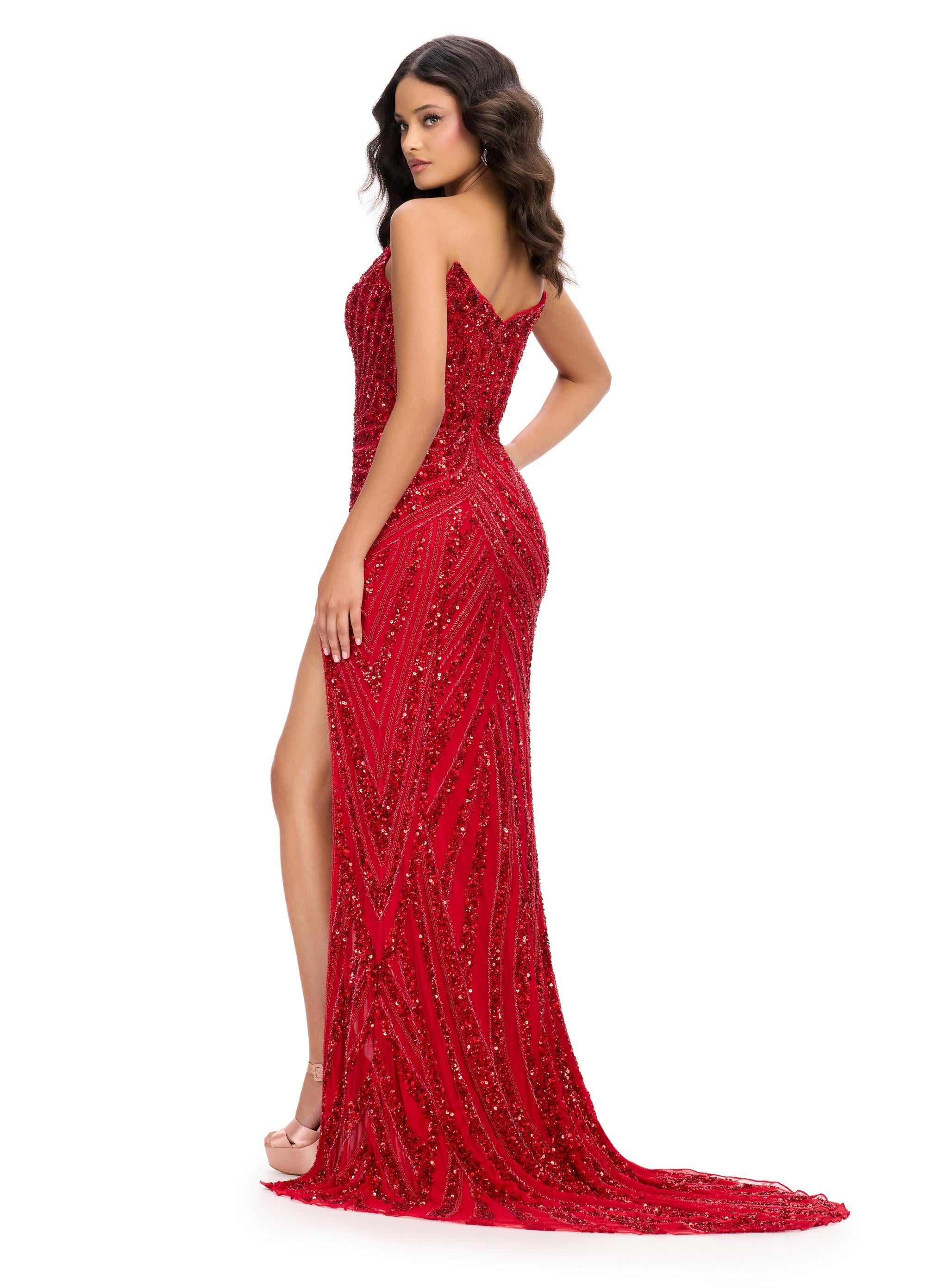 Back. Red ASHLEYlauren 11236 strapless gown featuring a sweetheart neckline, modern floral sequin motif cascading down the bustier and skirt, and a left leg slit for a glamorous and head-turning look.