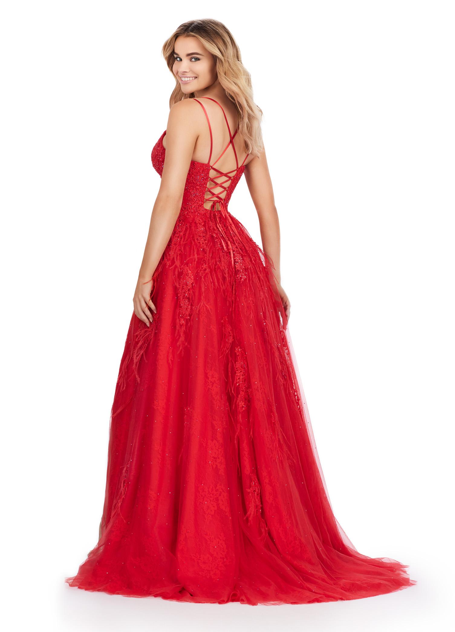 Back view. ASHLEYlauren 11480 red A-line gown with feather and jewel embellishments, corset bodice, lace up back, and left leg slit
