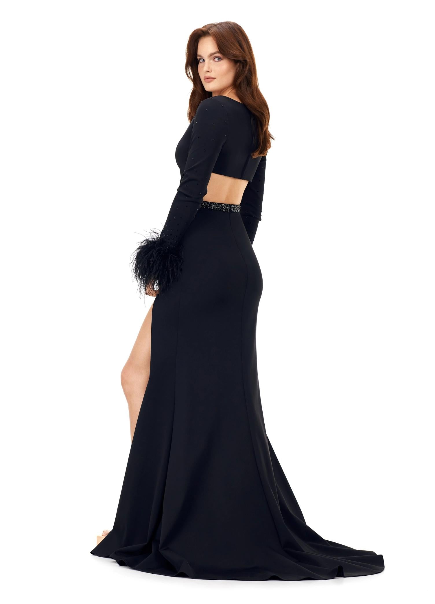 Back view. Black ASHLEYlauren 11308 striking scuba gown featuring a deep V-neckline, criss-cross cut out bodice, crystal waistline, long sleeves adorned with heat-set stones and feather trim, a fitted skirt, and a left leg slit for a bold and glamorous statement look.