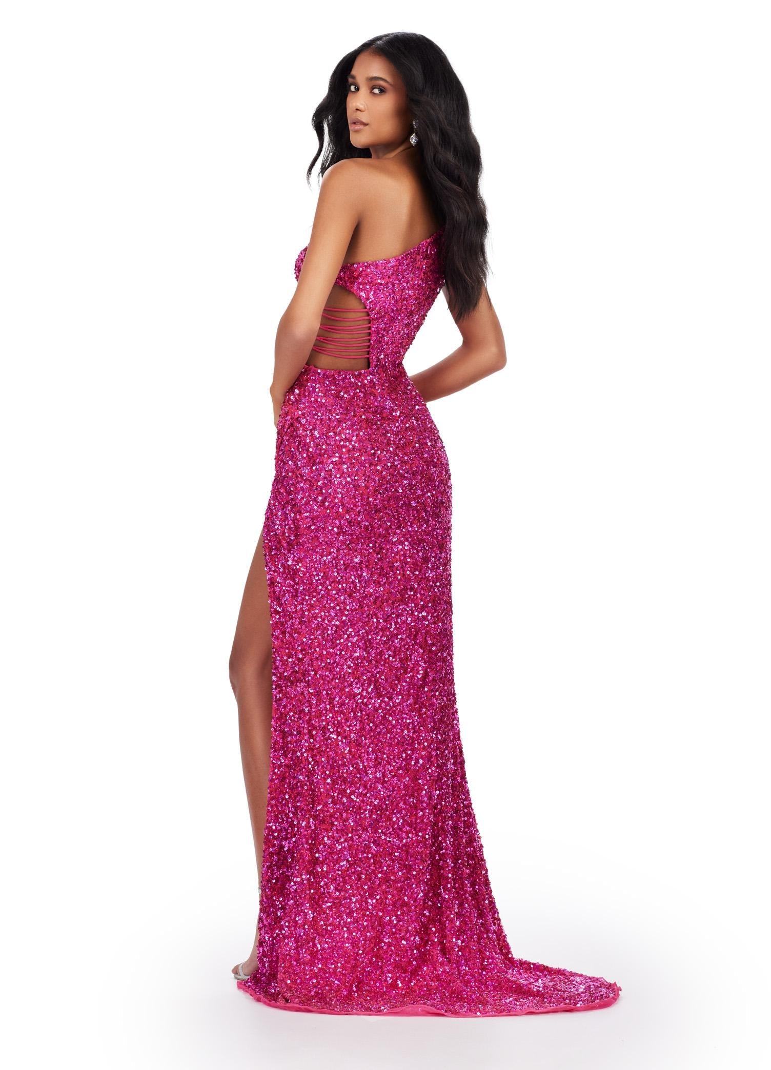 Back view. Fuchsia ASHLEYlauren 11288 stunning one shoulder fully hand-beaded gown featuring modern cut outs, criss cross waist straps, a left leg slit, and a sweep train for a bold and statement-making entrance.