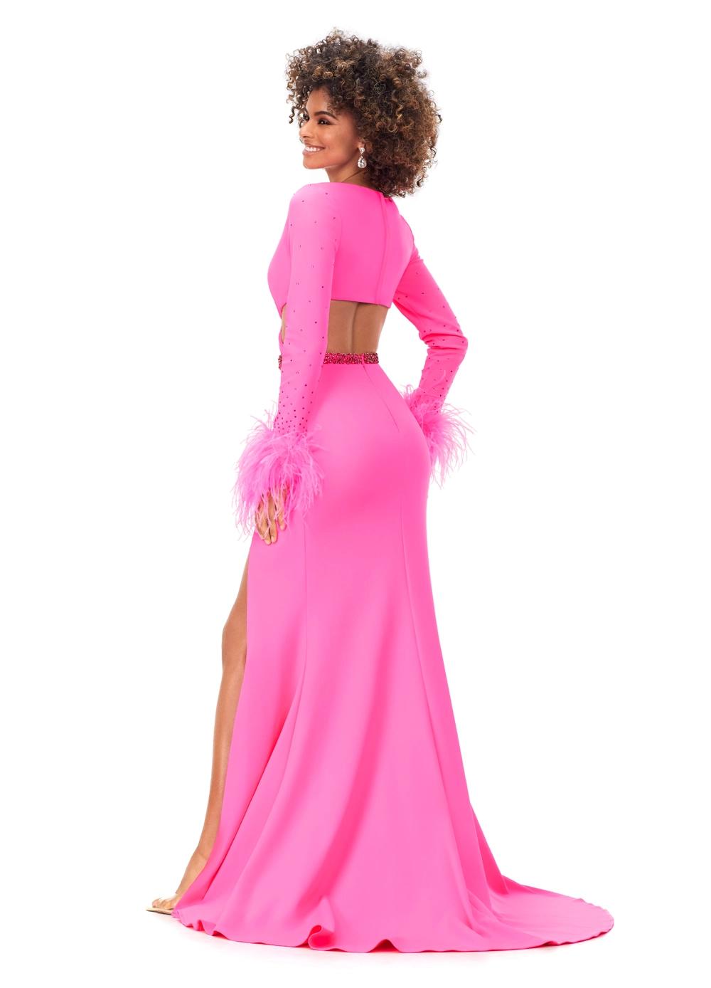 Back view. Hot Pink ASHLEYlauren 11308 striking scuba gown featuring a deep V-neckline, criss-cross cut out bodice, crystal waistline, long sleeves adorned with heat-set stones and feather trim, a fitted skirt, and a left leg slit for a bold and glamorous statement look.
