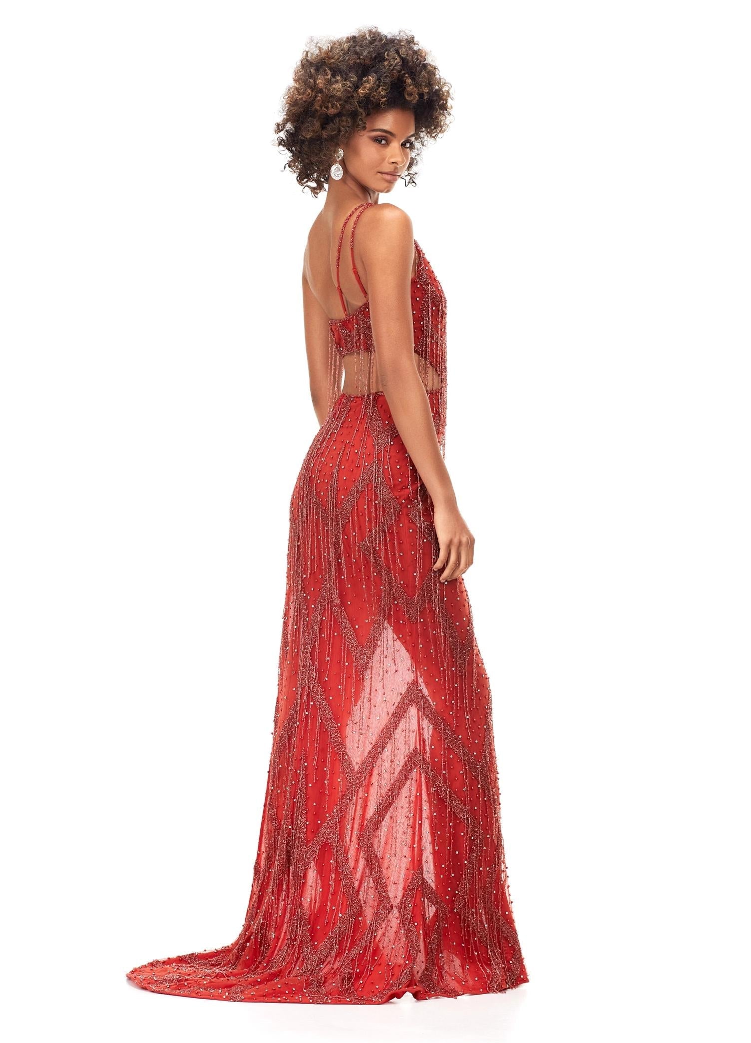 Back view. Orange ASHLEYlauren 11280 daring one shoulder gown featuring an intricate bead pattern, scattered fringe accents, bold side cut outs, and a left leg slit for a striking and glamorous statement look.