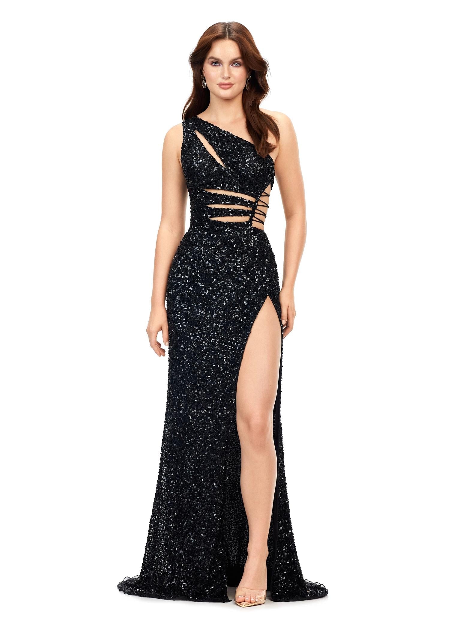 Black ASHLEYlauren 11288 stunning one shoulder fully hand-beaded gown featuring modern cut outs, criss cross waist straps, a left leg slit, and a sweep train for a bold and statement-making entrance.