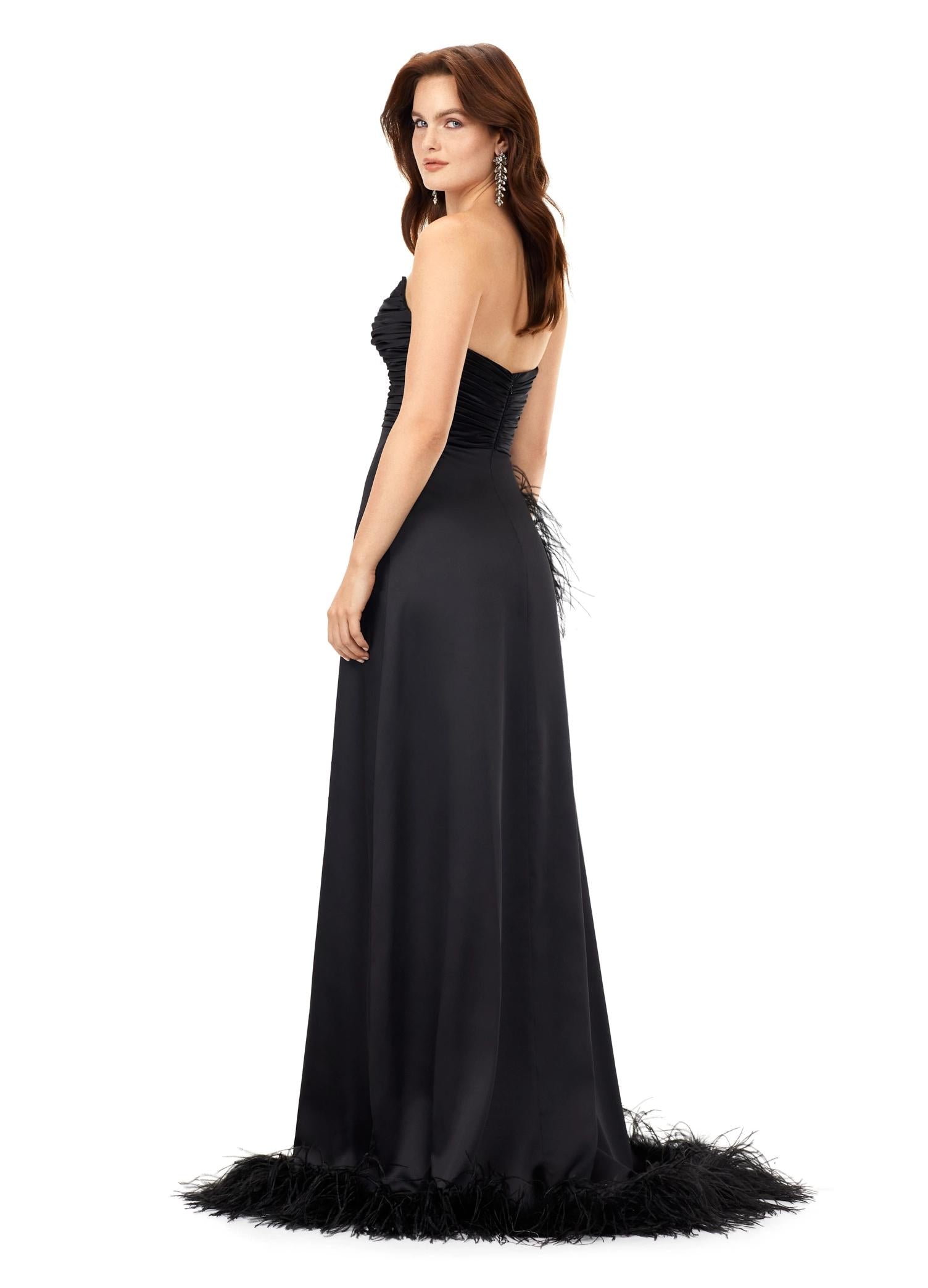 Back - Black ASHLEYlauren 11313 strapless satin gown featuring a ruched bustier, slight A-line skirt, high right leg slit, and cascading feather trim along the hemline.