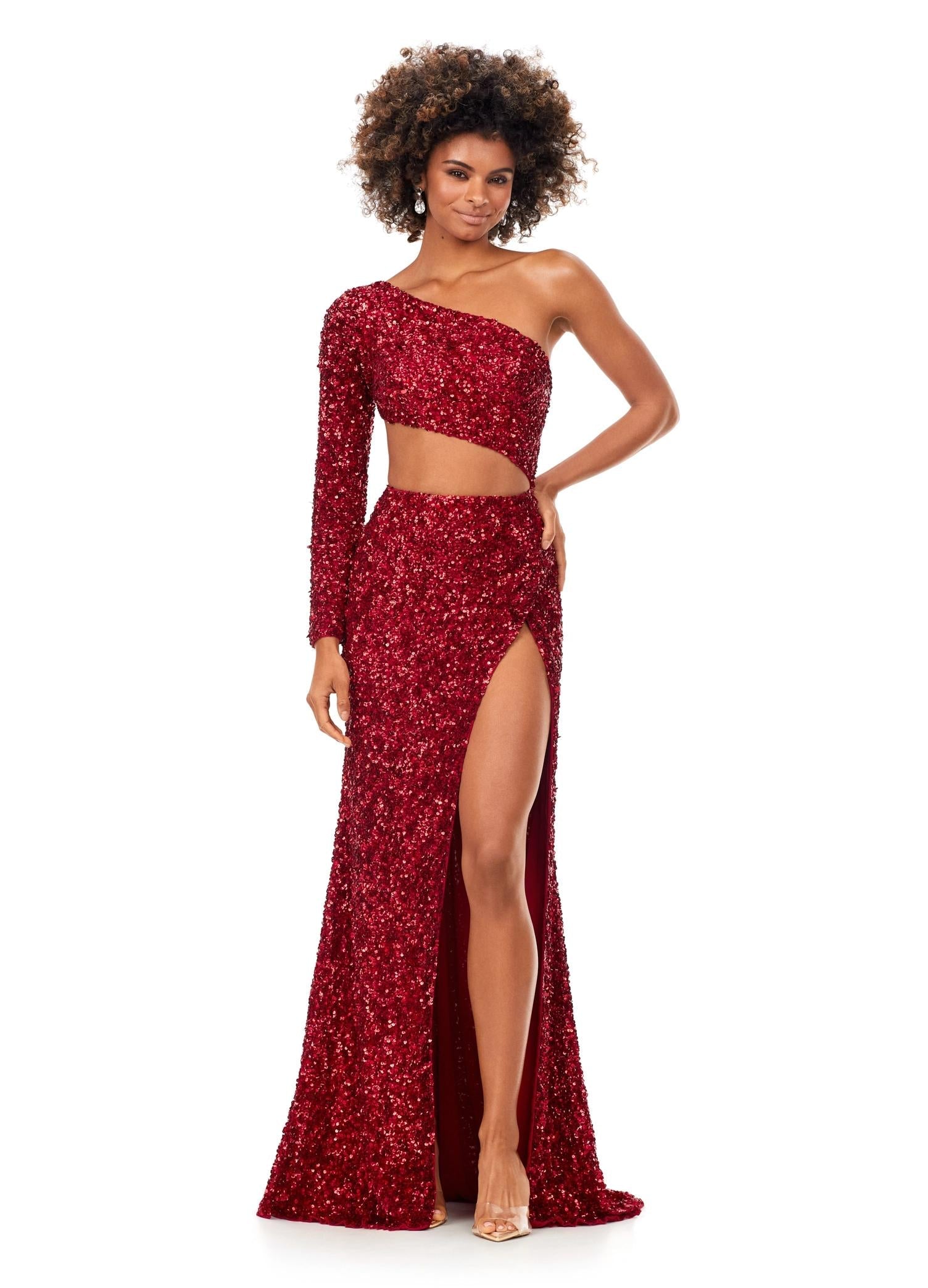 Red ASHLEYlauren 11340 sequin one shoulder gown featuring a single sleeve, shark bite cut-out, wrap skirt, and left leg slit for a striking and glamorous look.
