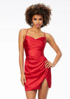 Red ASHLEYlauren 4513 satin cocktail dress featuring spaghetti straps, an exquisitely draped bodice, wrap fitted skirt with a left leg slit, and an open lace-up back for an elegant and sophisticated look.