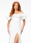 White ASHLEYlauren 11217 – A magnificent off-shoulder velvet gown featuring oversized ruffle details, a contour seamed skirt with a left leg slit, and a dramatic train. Perfect for making a bold, elegant statement at any event.