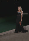 Video - Breathtaking strapless gown featuring a beaded corset bustier, a press-on stone embellished skirt, a left leg slit, and a sweep train for an elegant and glamorous finish. Perfect for special occasions.