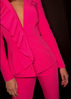 Video - Statement two-piece jersey jumpsuit featuring a ruffle-adorned V-neckline and sleek flare pants for a bold and sophisticated look. Perfect for making an entrance at any event.
