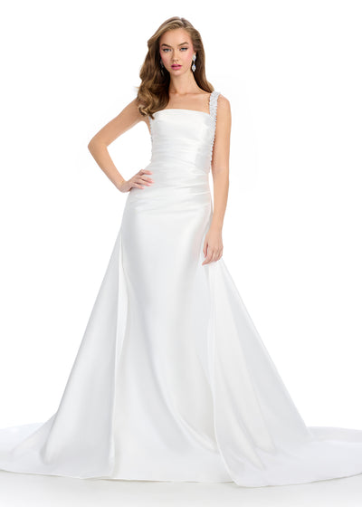 Regal mikado gown featuring fully beaded straps, a ruched bustier for a flattering fit, a sleek column skirt, and a sweeping overskirt for a dramatic, timeless look. Perfect for making a grand entrance.