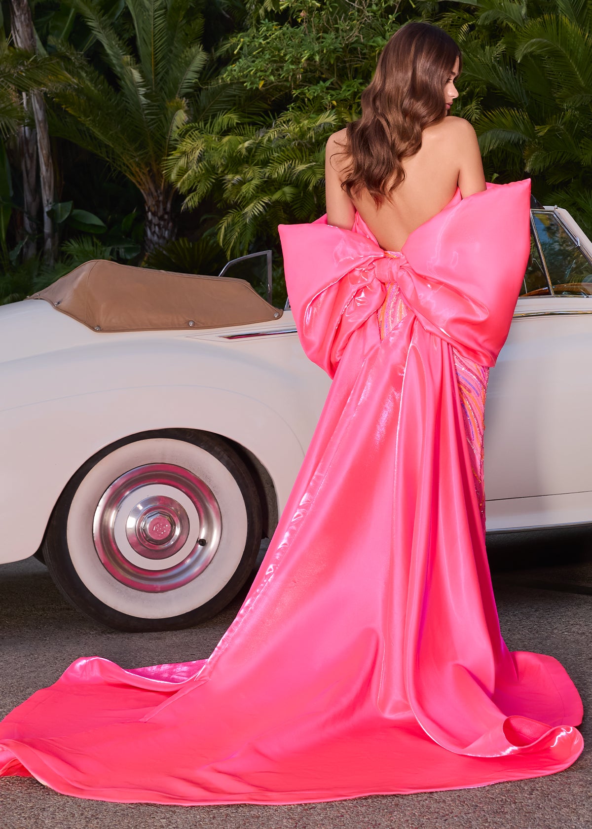 Statement-making off-shoulder cape featuring an oversized bow and flowing overskirt. The perfect accessory to elevate your prom or pageant look with elegance and drama.