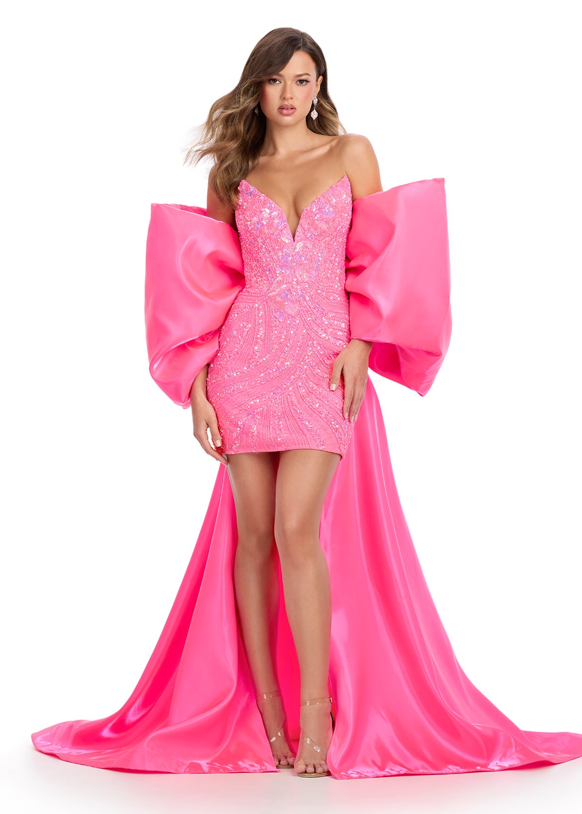 Statement-making off-shoulder cape featuring an oversized bow and flowing overskirt. The perfect accessory to elevate your prom or pageant look with elegance and drama.