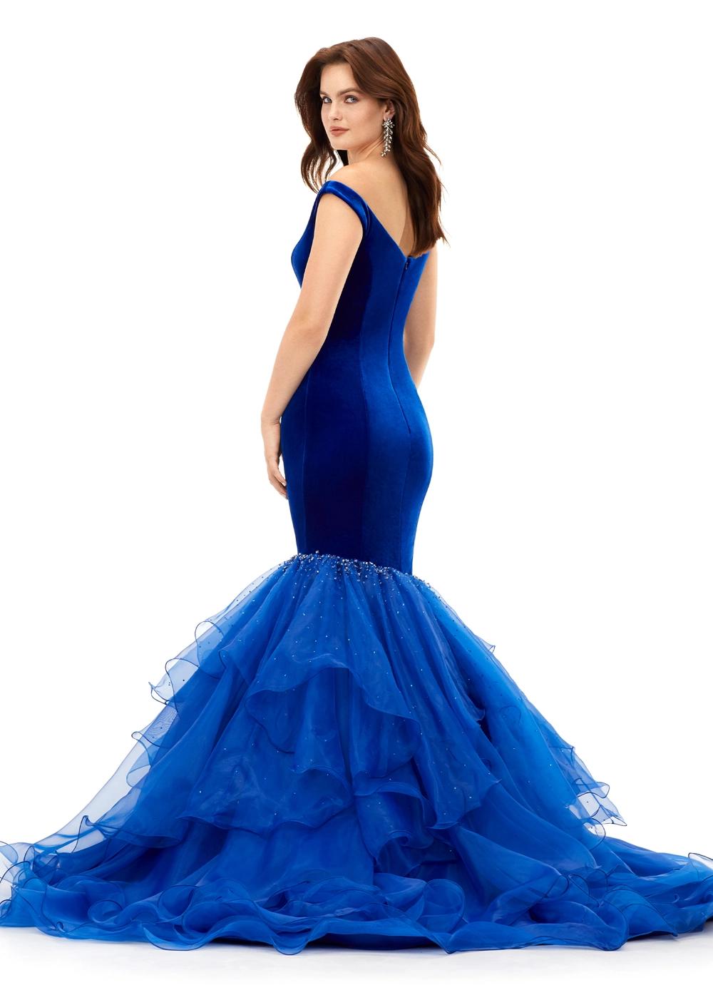 Back. Royal ASHLEYlauren 11312 off shoulder velvet gown featuring a princess-seamed bodice, asymmetric organza ruffle fit and flare skirt, cascading crystal accents, and a sweep train for a dramatic and elegant look.