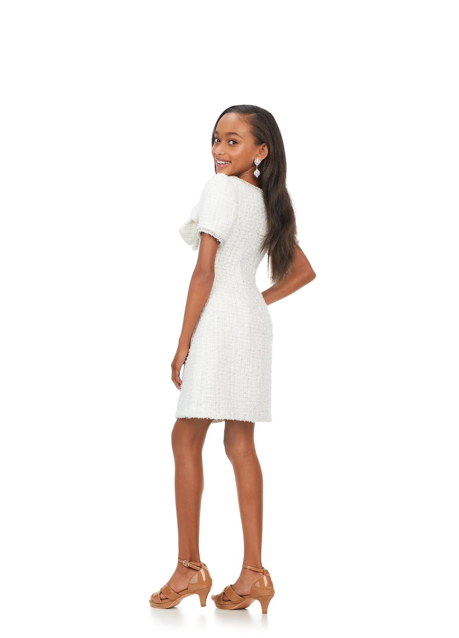 Back. Ivory ASHLEYlauren Kids 8172 multi tweed cocktail dress featuring a crew neckline, short sleeves trimmed with pearls and crystals, and a beautiful bow detail on the bodice for a chic and elegant look.