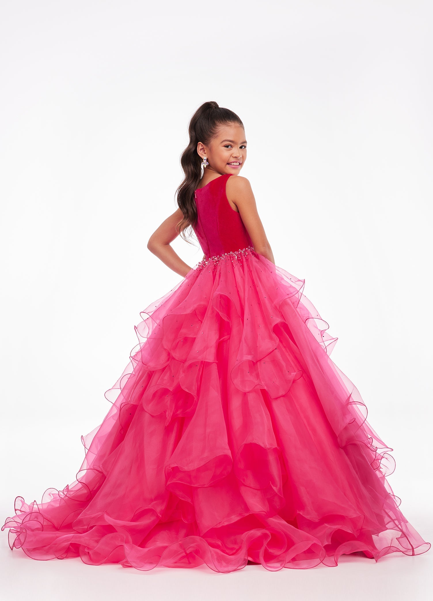 Back. Pink ASHLEYlauren Kids 8120 elegant ball gown featuring a crew neckline, velvet bustier, beaded waistline, and cascading press-on stone details over a handkerchief organza skirt for a sophisticated and graceful look.