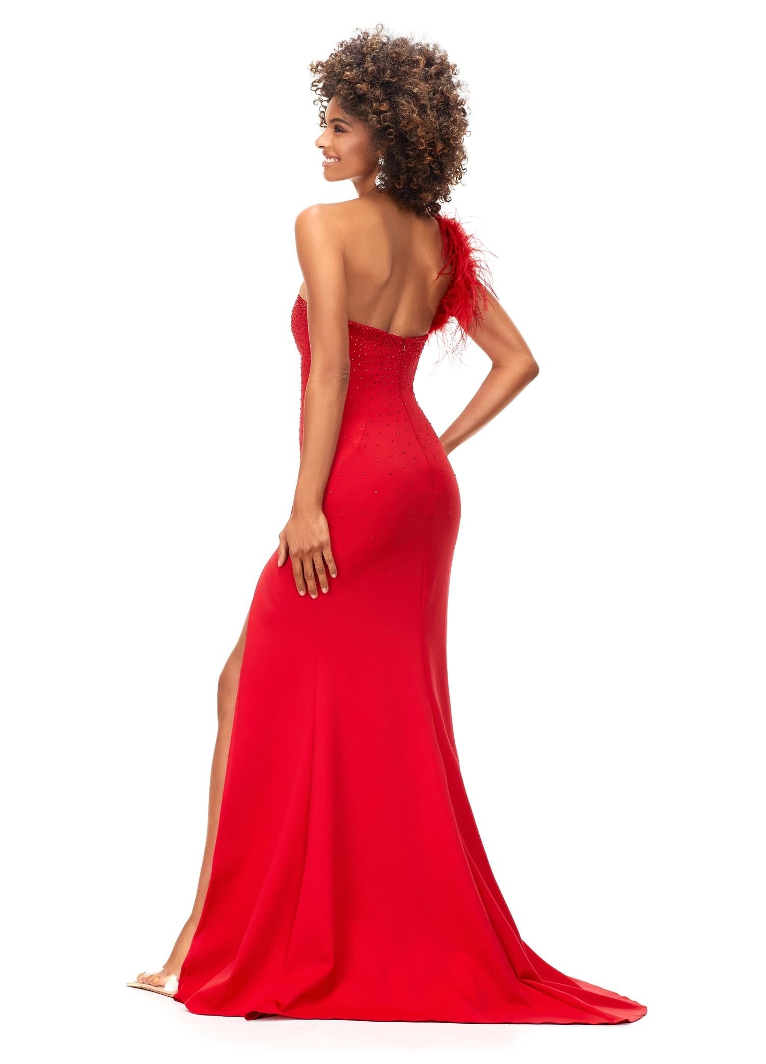 ASHLEYlauren 11290 | Red one shoulder scuba gown featuring feather-embellished neckline, heat set stones cascading down the skirt, and a left leg slit for a bold and elegant look.