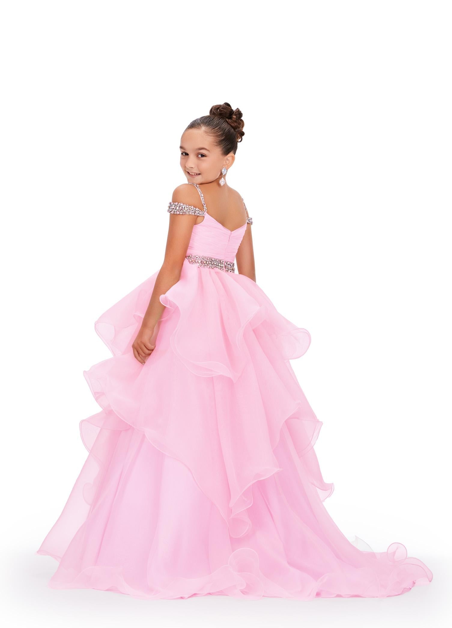 Back - Ice Pink ASHLEYlauren 8250 dreamy kids ball gown featuring an off-shoulder design, crystal-encrusted straps, ruched bodice, beaded waistline, and a dramatic ruffle organza skirt for a fairytale-inspired look.