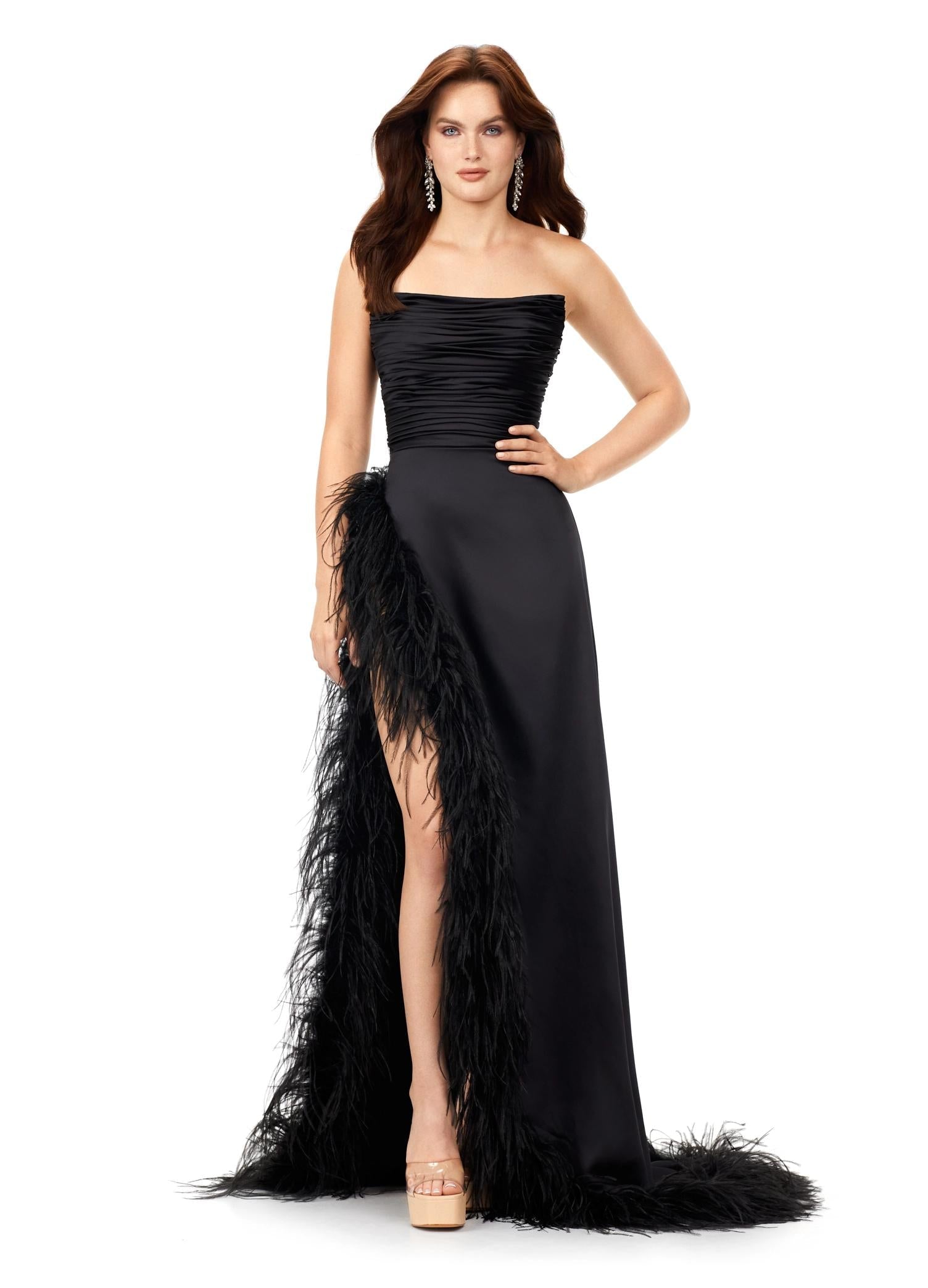 Black ASHLEYlauren 11313 strapless satin gown featuring a ruched bustier, slight A-line skirt, high right leg slit, and cascading feather trim along the hemline.
