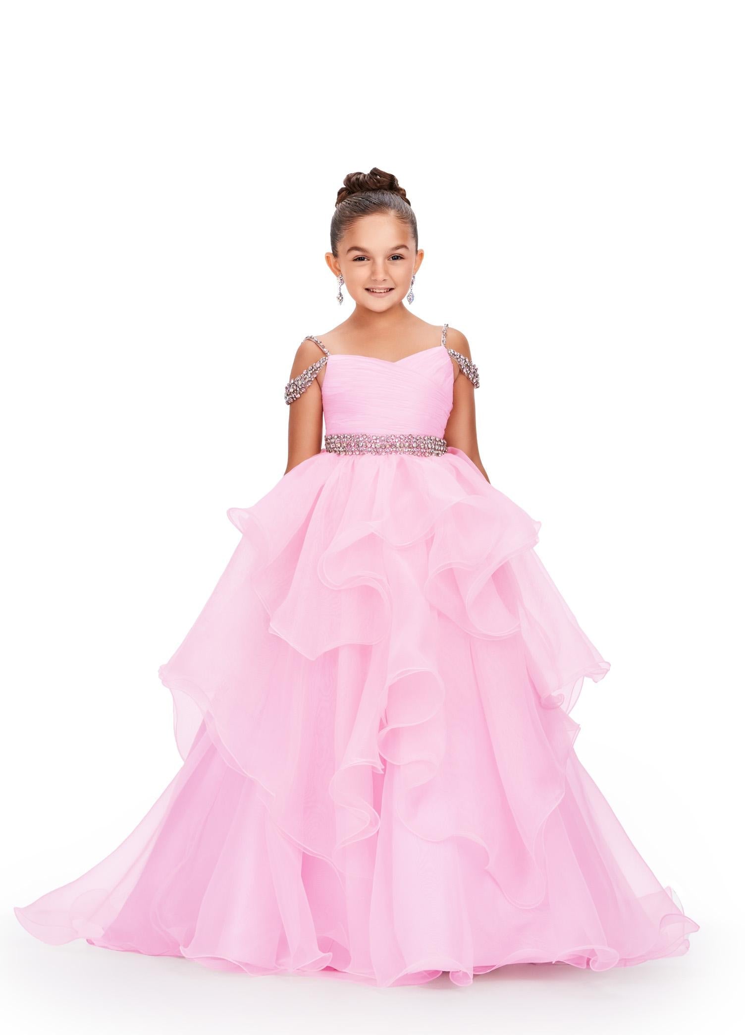 Ice Pink ASHLEYlauren 8250 dreamy kids ball gown featuring an off-shoulder design, crystal-encrusted straps, ruched bodice, beaded waistline, and a dramatic ruffle organza skirt for a fairytale-inspired look.