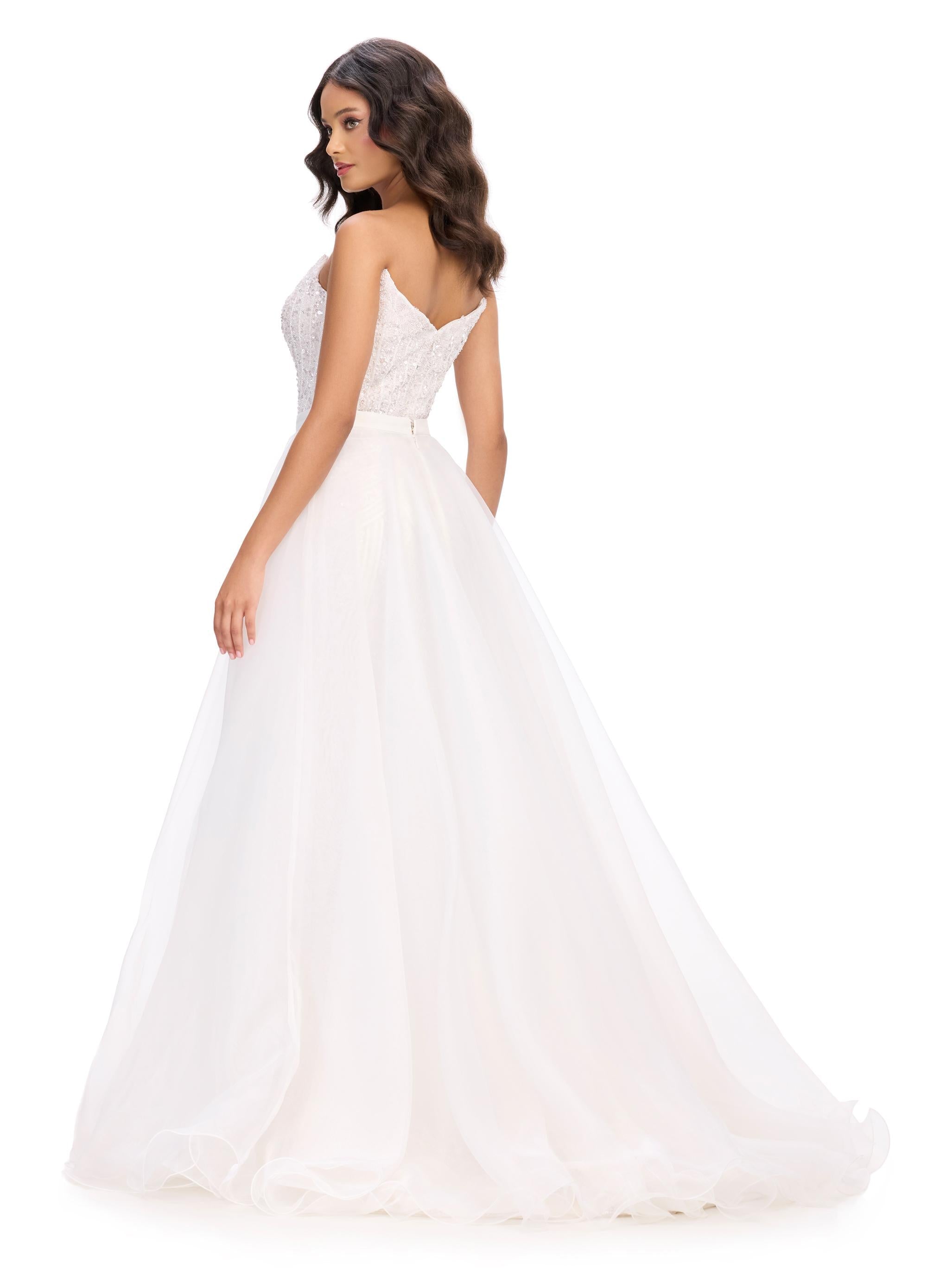 Back -  Elevate your look with this stunning layered organza overskirt featuring a structured wire hem and a sweeping train. The perfect statement piece to add flair to any dress, romper, bodysuit, or jumpsuit.