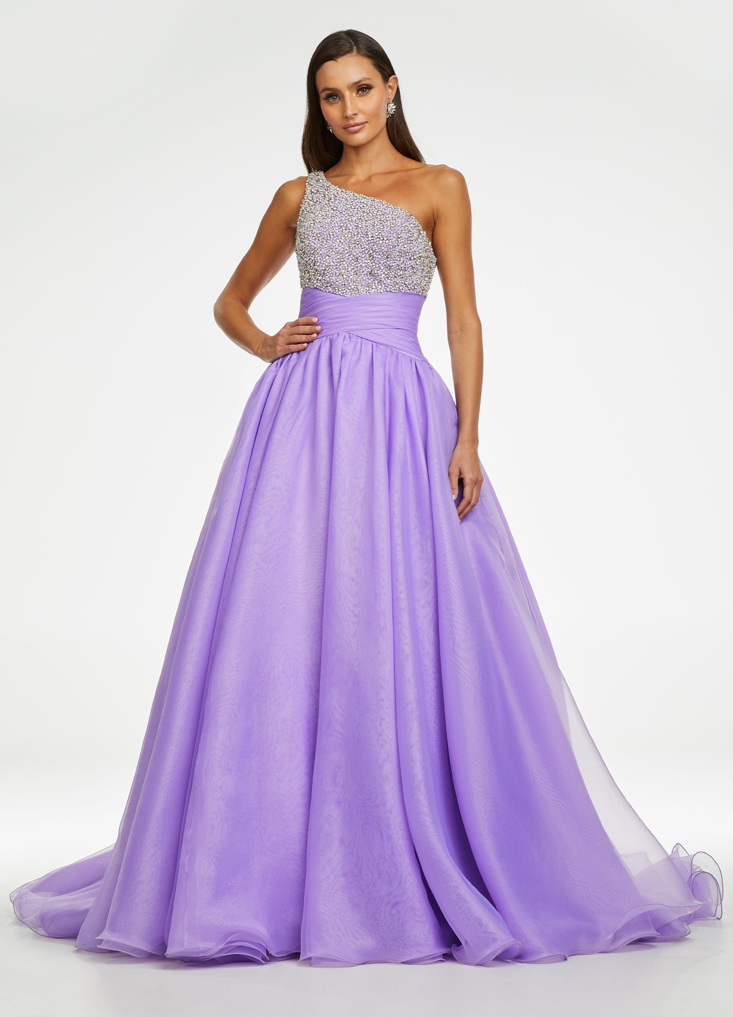 Lilac ASHLEYlauren 11127 – An elegant one-shoulder organza ball gown featuring an encrusted crystal and pearl detail bustier, a ruched wrap waist for a flattering silhouette, and a full ball gown skirt. Perfect for any formal event.