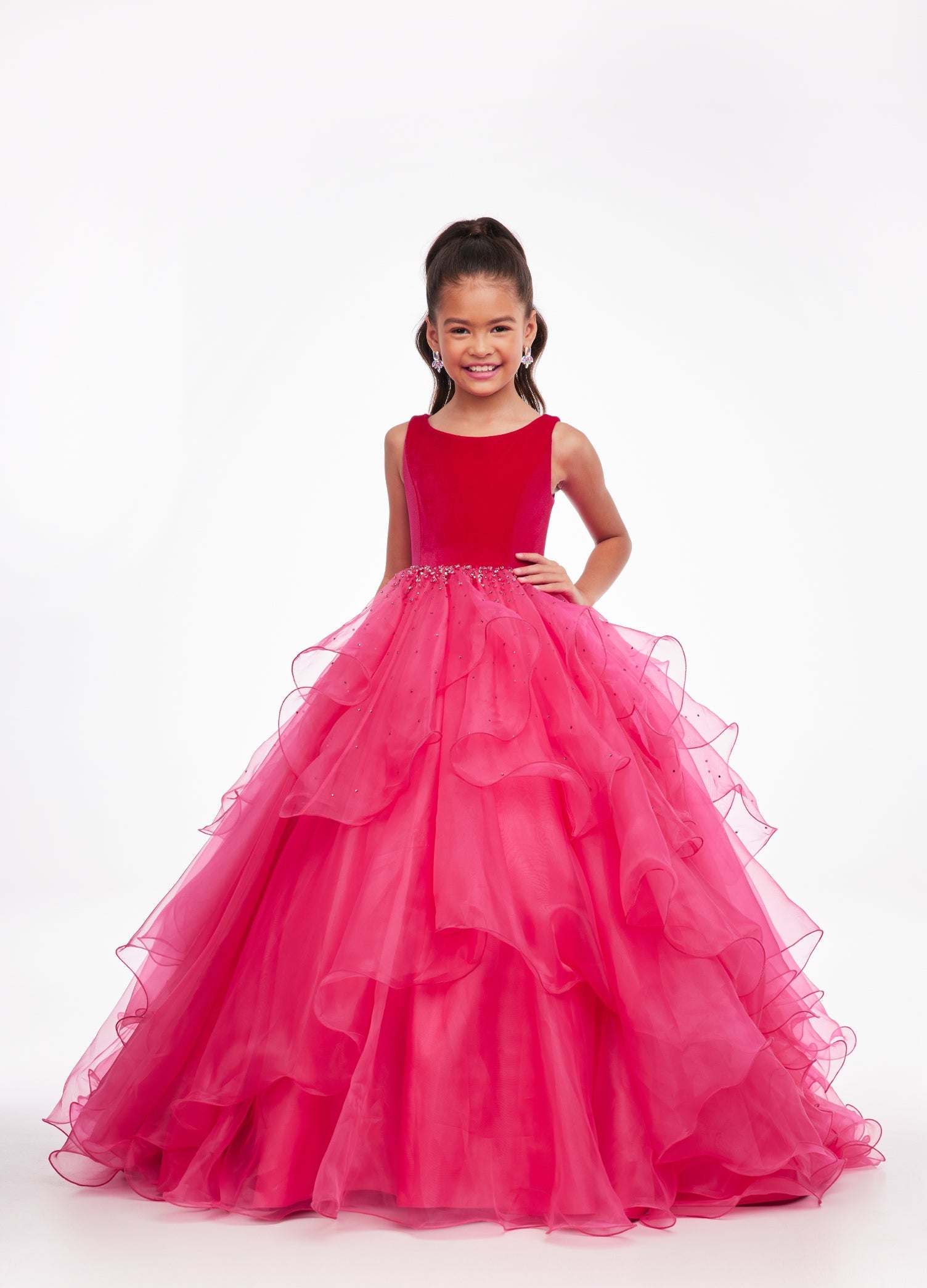 Pink ASHLEYlauren Kids 8120 elegant ball gown featuring a crew neckline, velvet bustier, beaded waistline, and cascading press-on stone details over a handkerchief organza skirt for a sophisticated and graceful look.