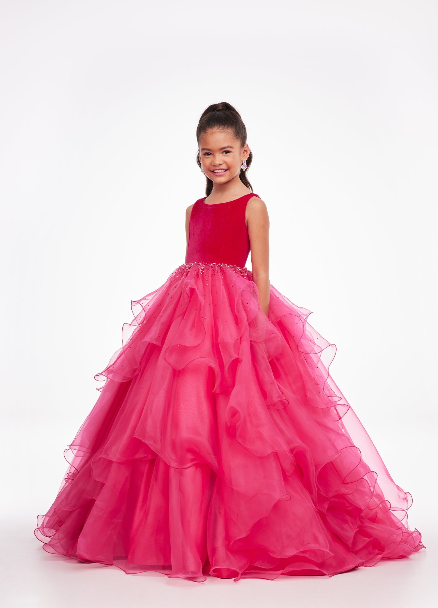 Pink ASHLEYlauren Kids 8120 elegant ball gown featuring a crew neckline, velvet bustier, beaded waistline, and cascading press-on stone details over a handkerchief organza skirt for a sophisticated and graceful look.