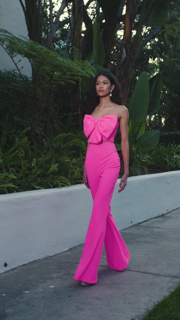 ASHLEYlauren 12291 | Hot Pink two piece scuba jumpsuit with strapless oversized bow top, high waisted flare pants, and sleek modern silhouette