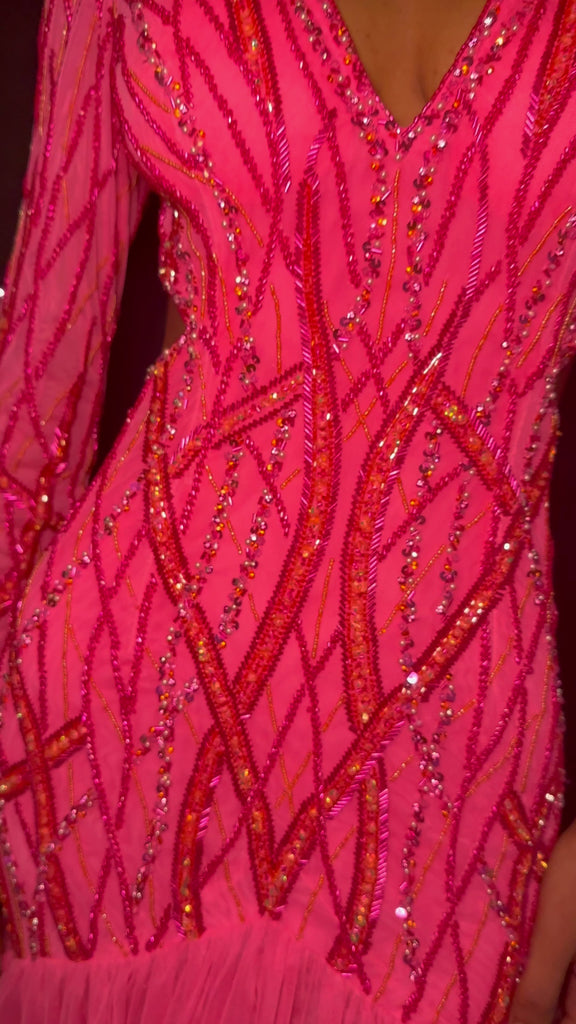 Video - Pink ASHLEYlauren 11436 stunning fully beaded gown featuring a V-neckline, open back, long sleeves, and a tiered ruffle skirt with a center slit for a show-stopping entrance.