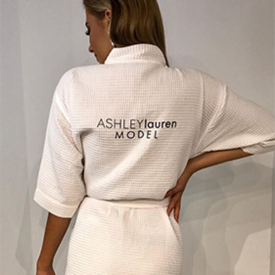 Young model wearing dress with words ASHLEYlauren MODEL